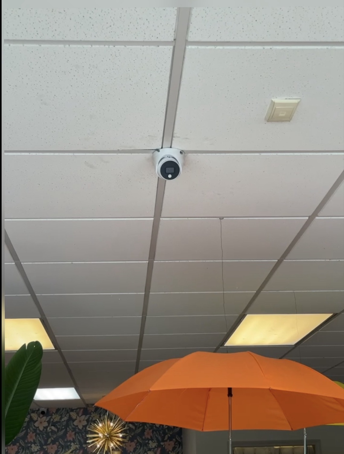 Indoor security camera installed in a retail space ceiling